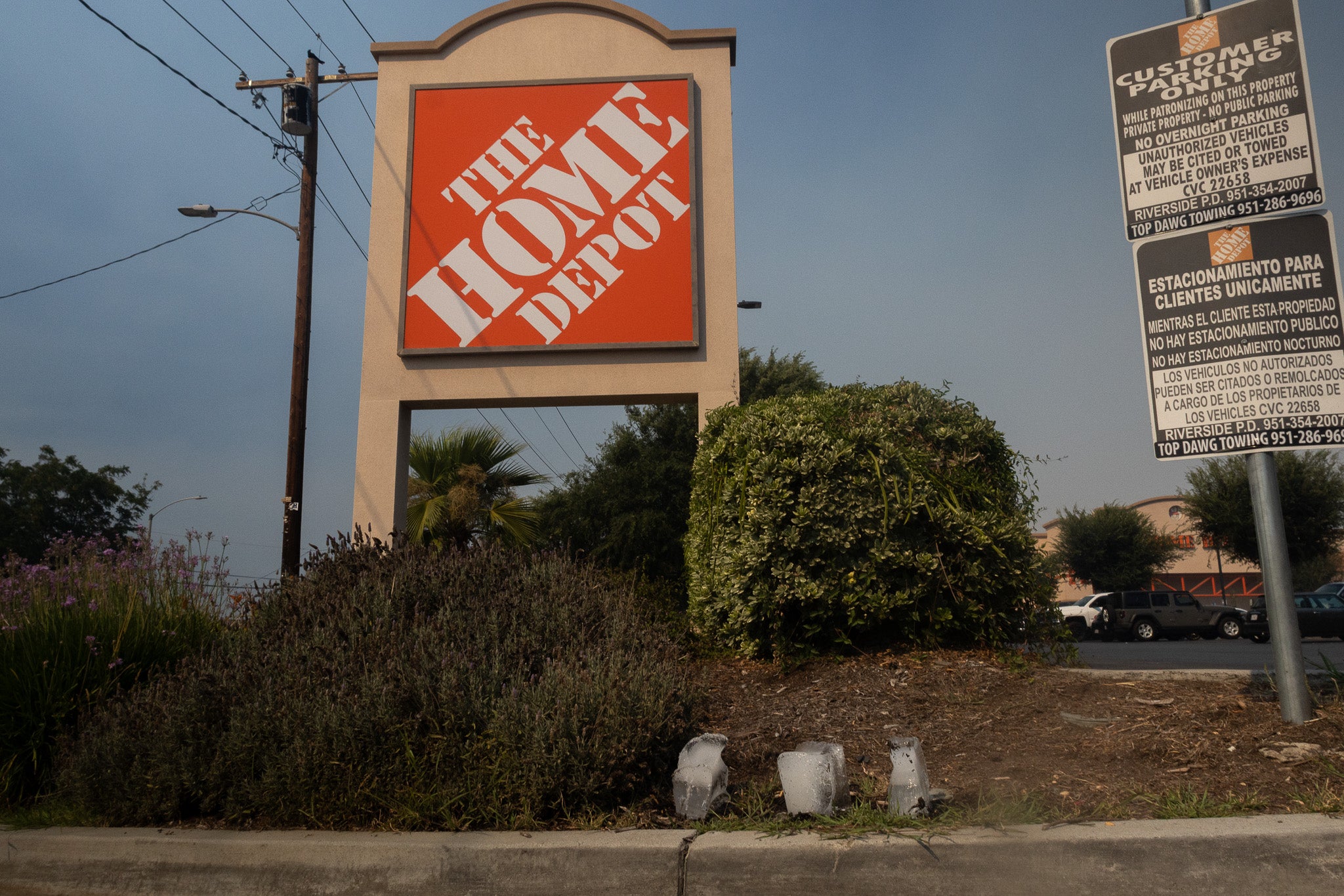 Home Depot sign with a clear sky background and three ice blocks melting