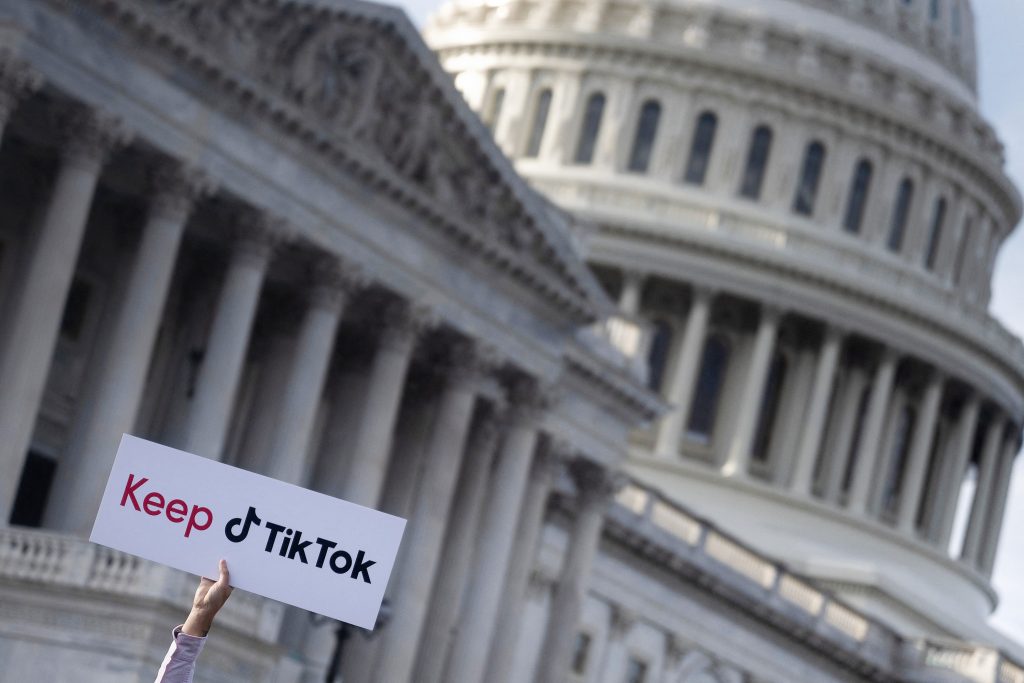 Person holding a 'Keep TikTok' sign in front of the U.S. Capitol building
